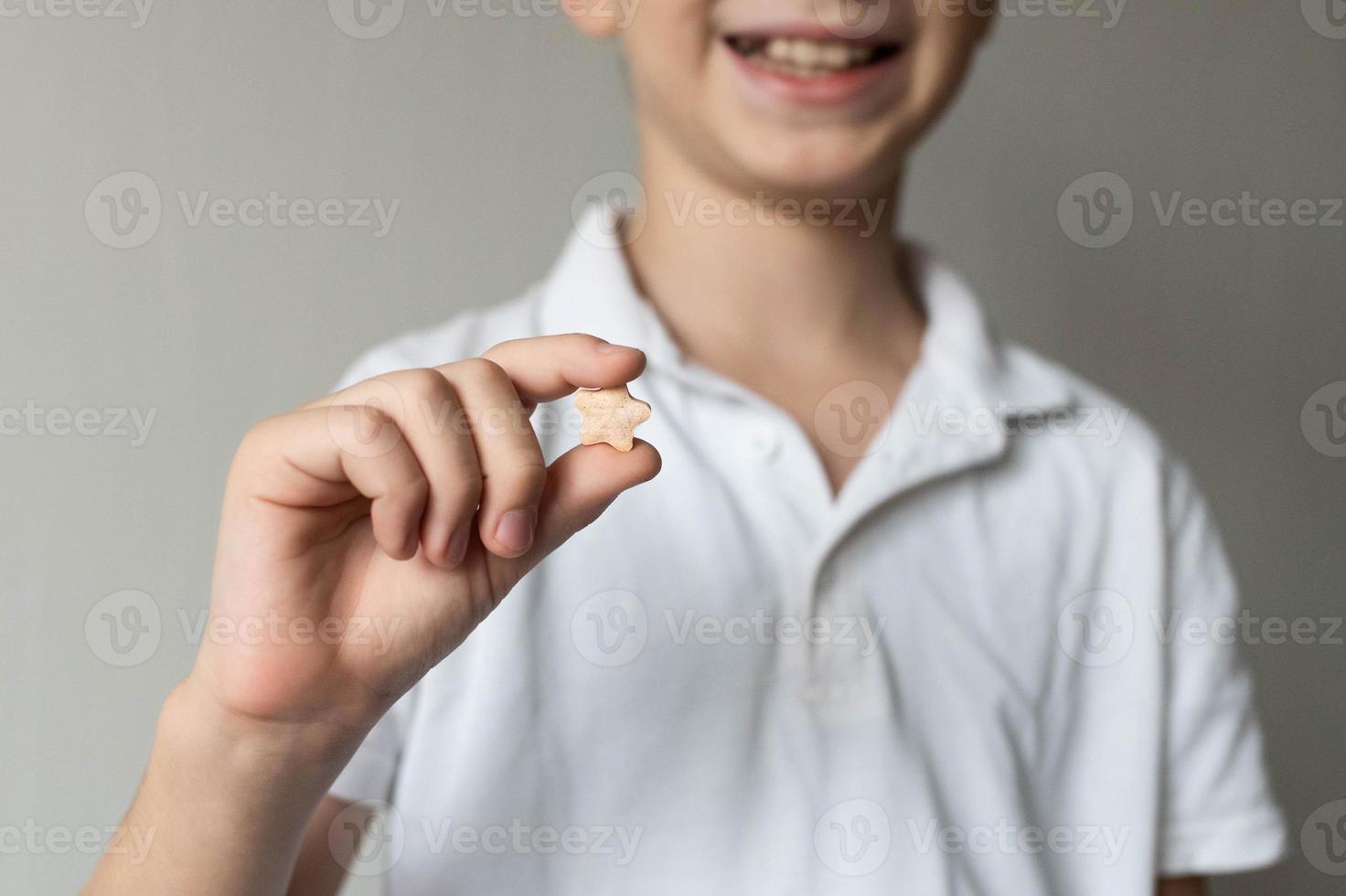 in de handen van een kind, een vitamine in de vorm van een asterisk foto