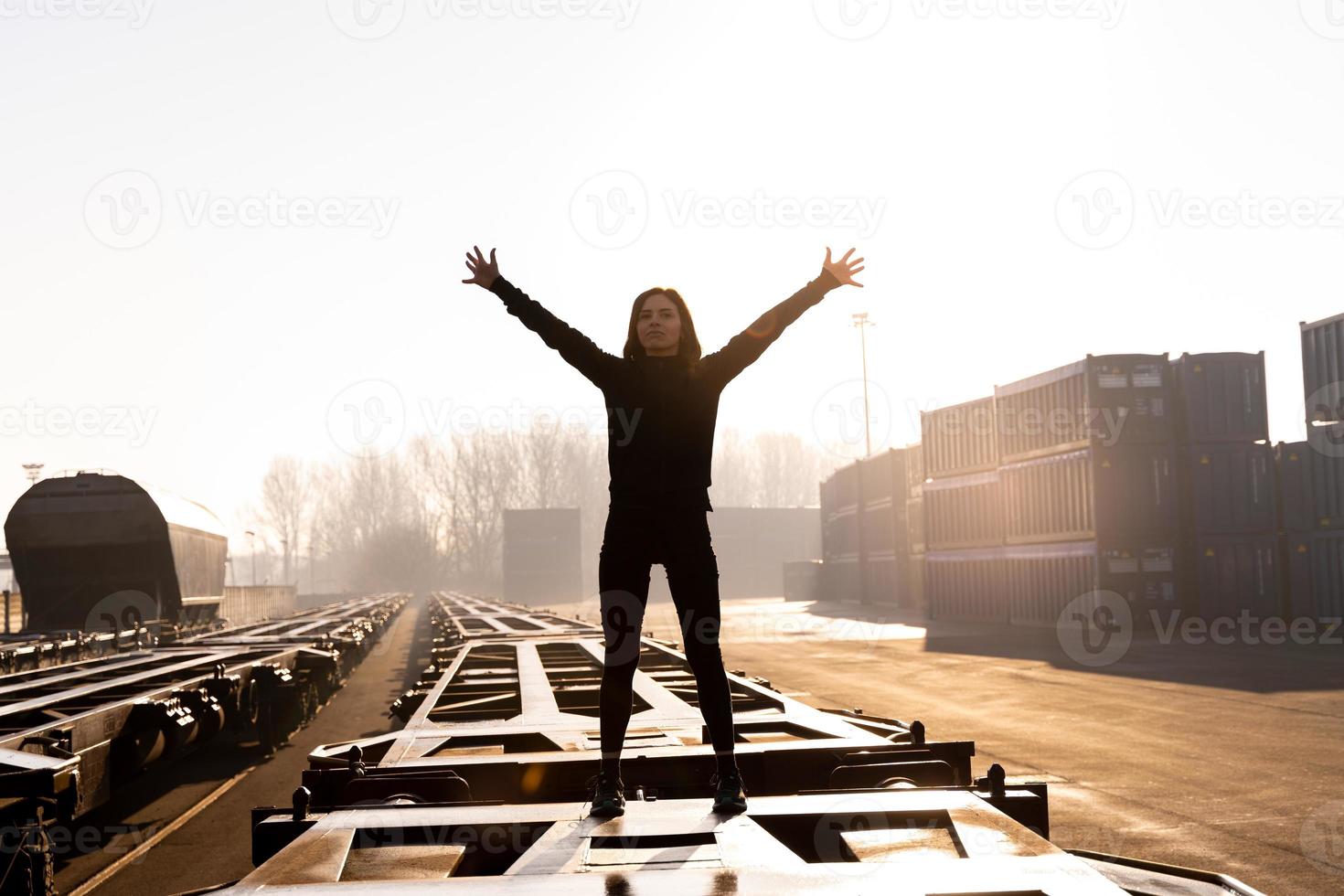 jong vrouw loper duurt een breken Aan een vracht trein in de reclame haven in de ochtend- foto