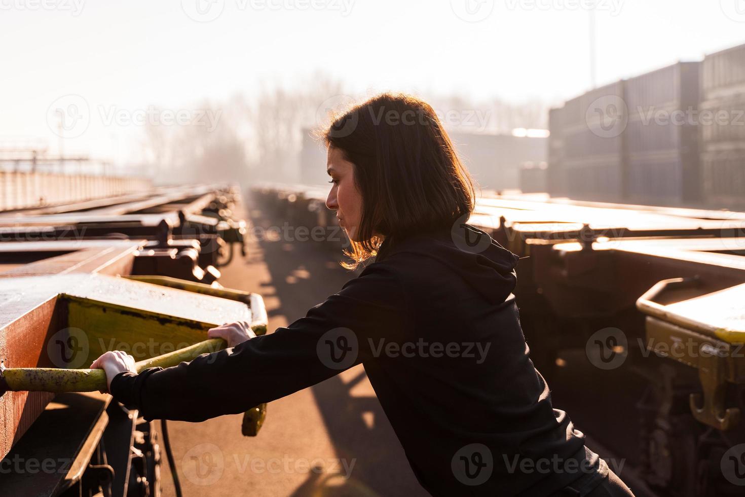 jong vrouw loper duurt een breken Aan een vracht trein in de reclame haven in de ochtend- foto