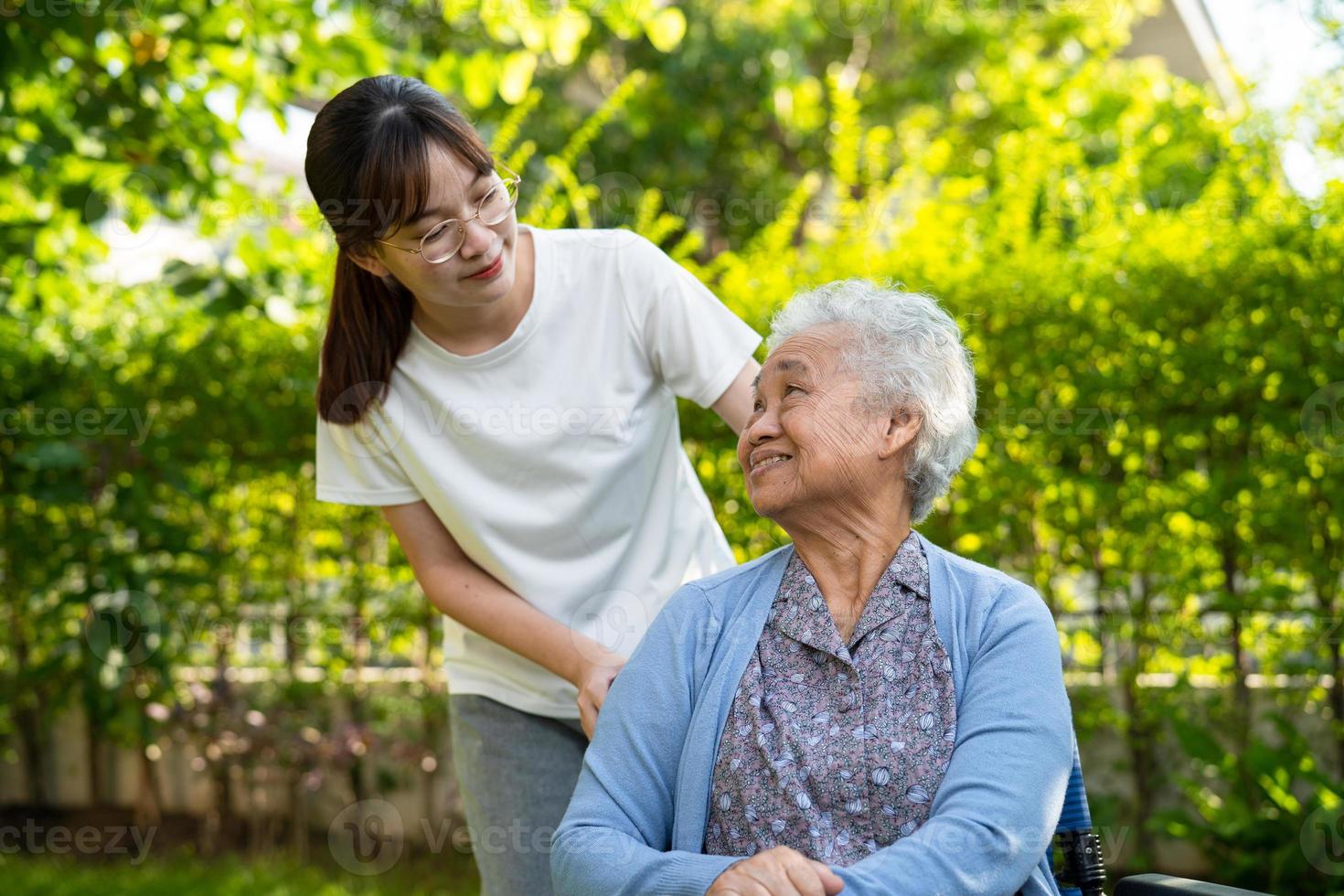 verzorger helpen en zorg Aziatisch ouderen vrouw gebruik wandelaar met sterk Gezondheid terwijl wandelen Bij park in gelukkig vers vakantie. foto