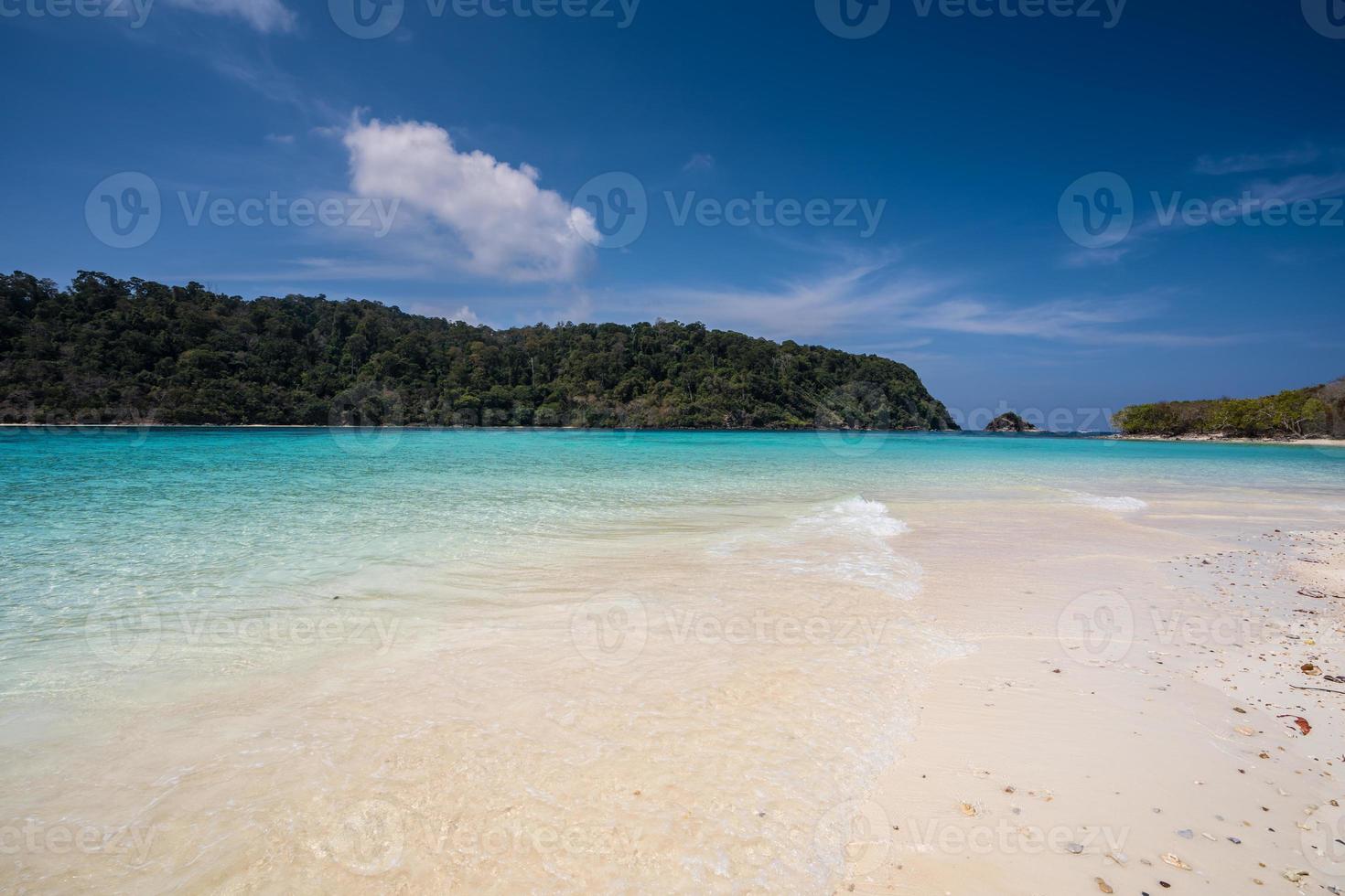 wit zandstrand met blauw water foto