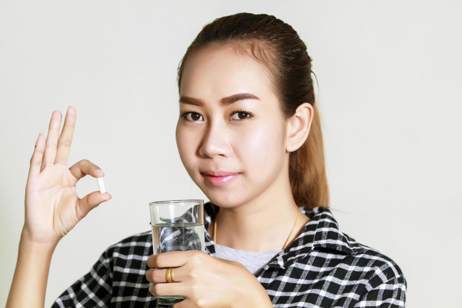 Aziatische vrouw die medicijnen gebruikt foto