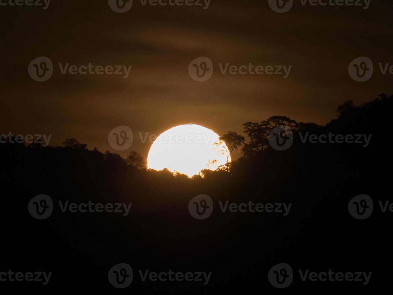 zon achter donkere wolken foto