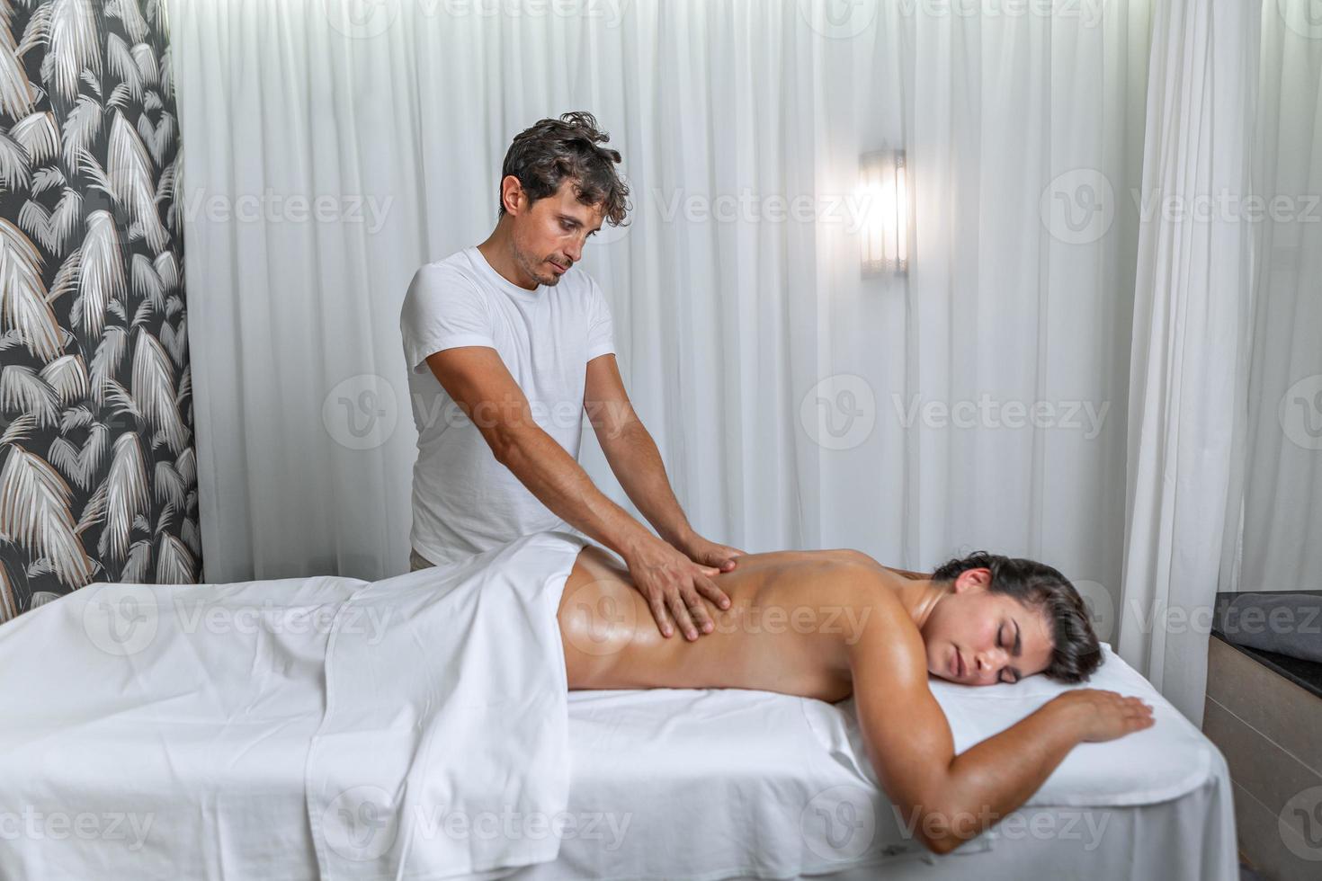 vrouw ontvangen terug massage Bij spa centrum door mannetje masseur foto