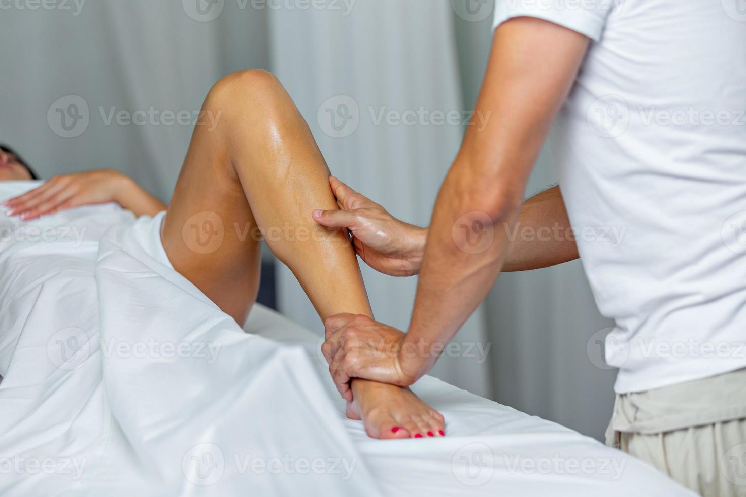 therapeut aan het doen een been massage naar vrouw in spa salon foto