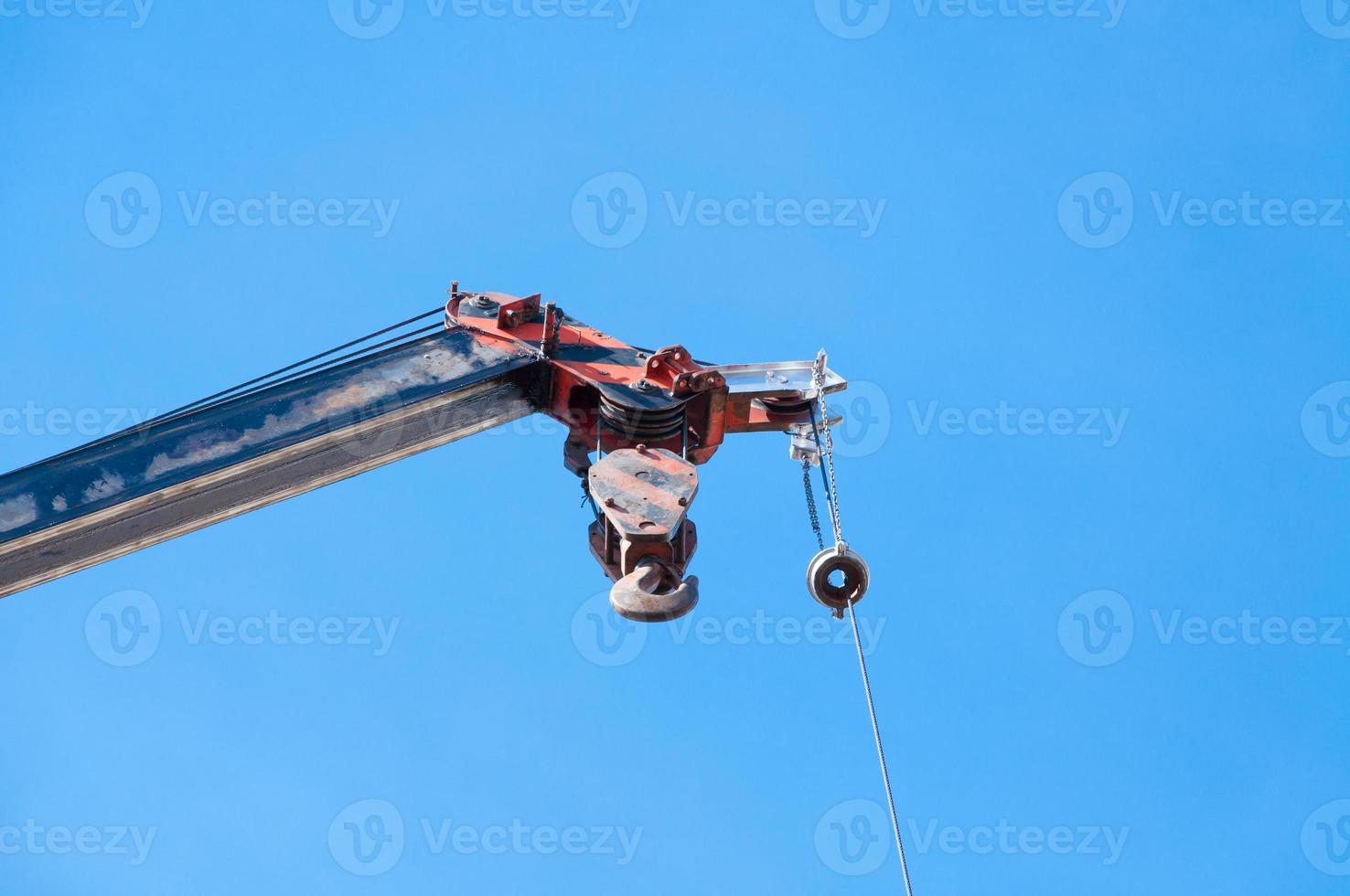 mobiel kraan boom met haak hangende door draad kabel achtergrond blauw hemel, dichtbij omhoog foto