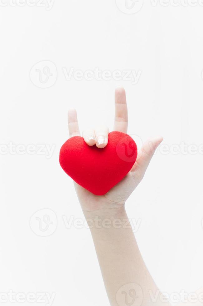 liefde teken door vrouw hand- en rood hart vorm Aan wit achtergrond close-up, symbool van liefde of dating valentijnsdag dag foto
