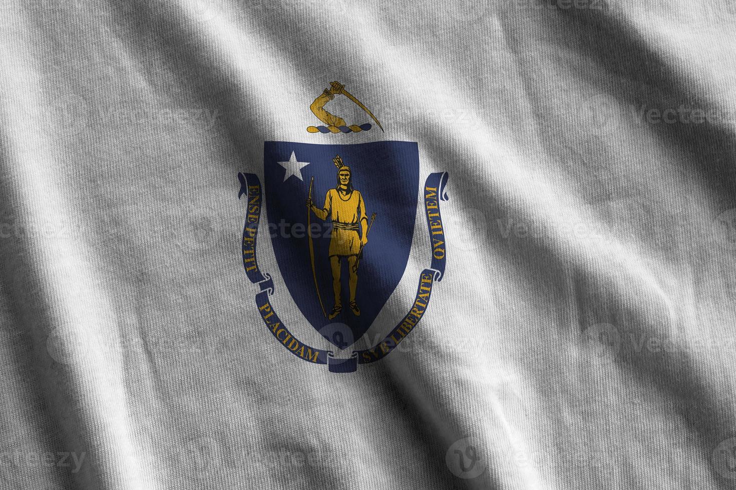 Massachusetts ons staat vlag met groot vouwen golvend dichtbij omhoog onder de studio licht binnenshuis. de officieel symbolen en kleuren in banier foto