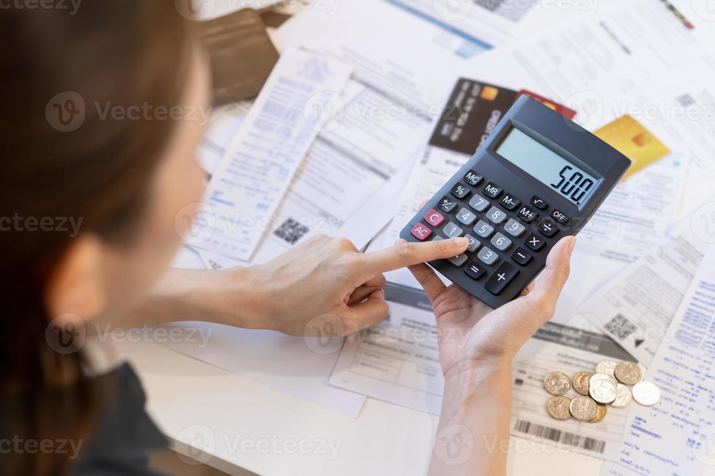 dichtbij omhoog hand- van spanning Aziatisch jong zakenvrouw gebruik makend van rekenmachine voor berekenen belasting, kosten van rekeningen, credit kaart voor betaling Aan ten gevolge deadline Aan tafel Bij huis. financieel, financiën mensen concept. foto