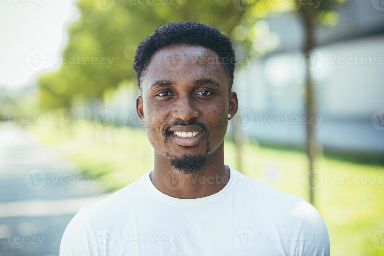 portret van jong millennial Afrikaanse Amerikaans Mens op zoek Bij camera gelukkig en glimlachen foto
