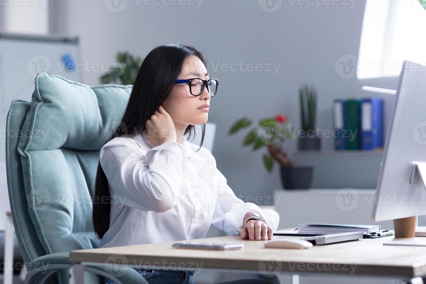 oververmoeid Aziatisch vrouw kantoor arbeider, heeft erge, ernstige nek pijn foto