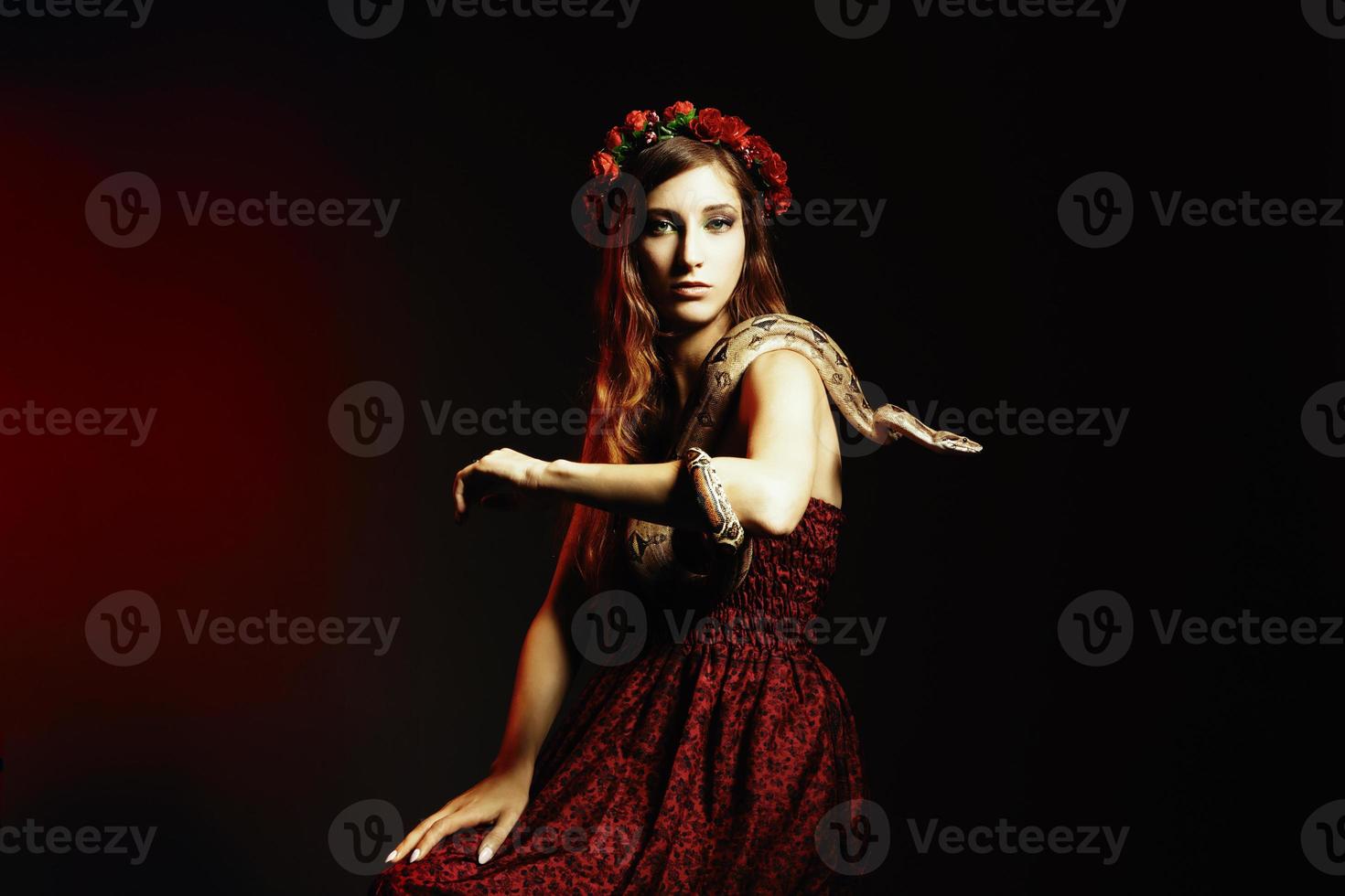aantrekkelijke roodharige vrouw poseren met een boa constrictor foto
