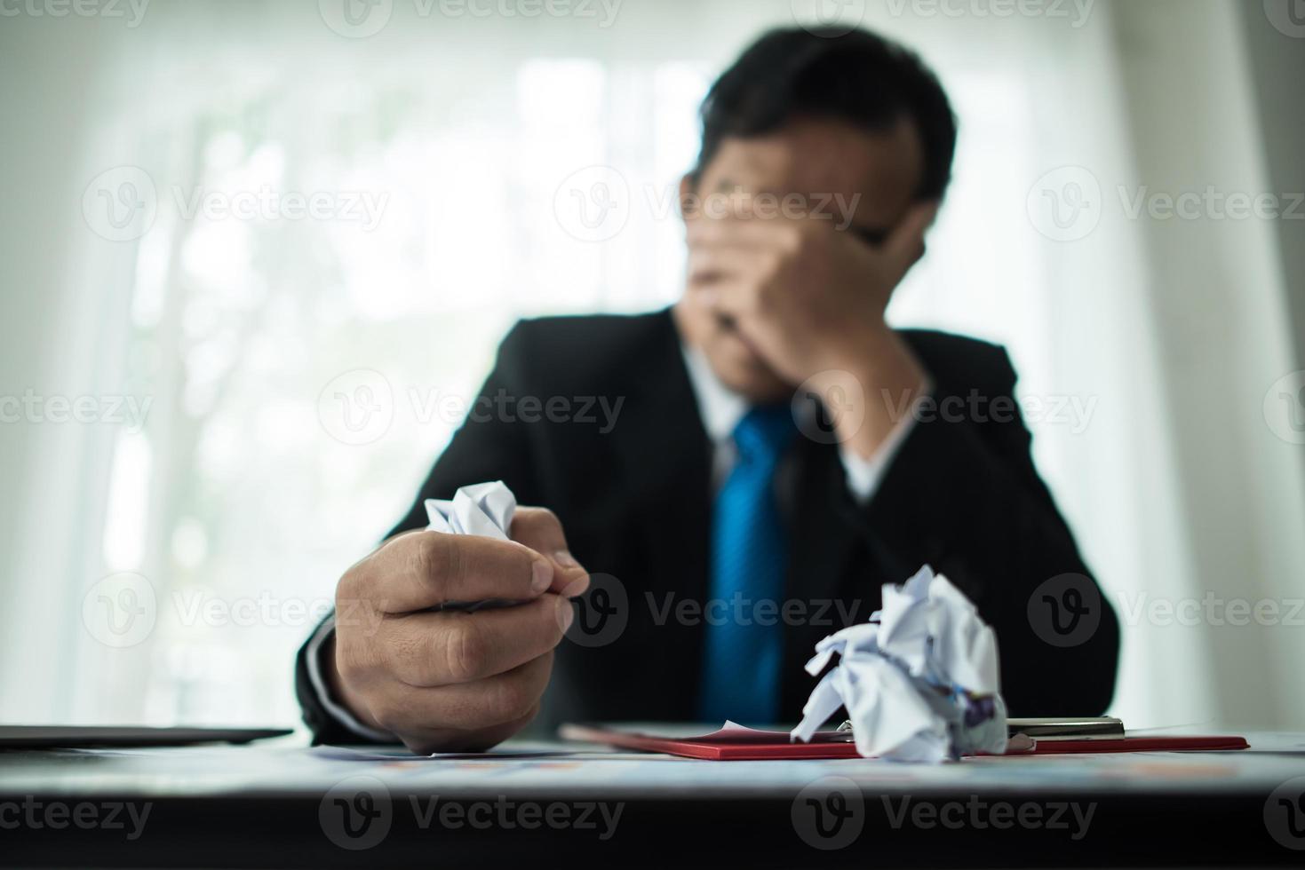jonge zakenman gefrustreerd aan bureau foto