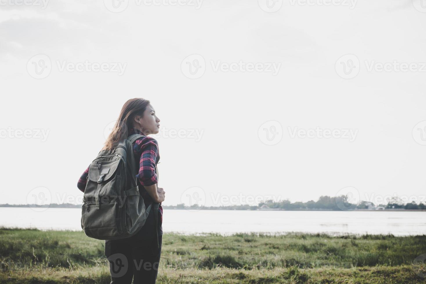 wandelaar vrouw met rugzak staande in de natuur foto