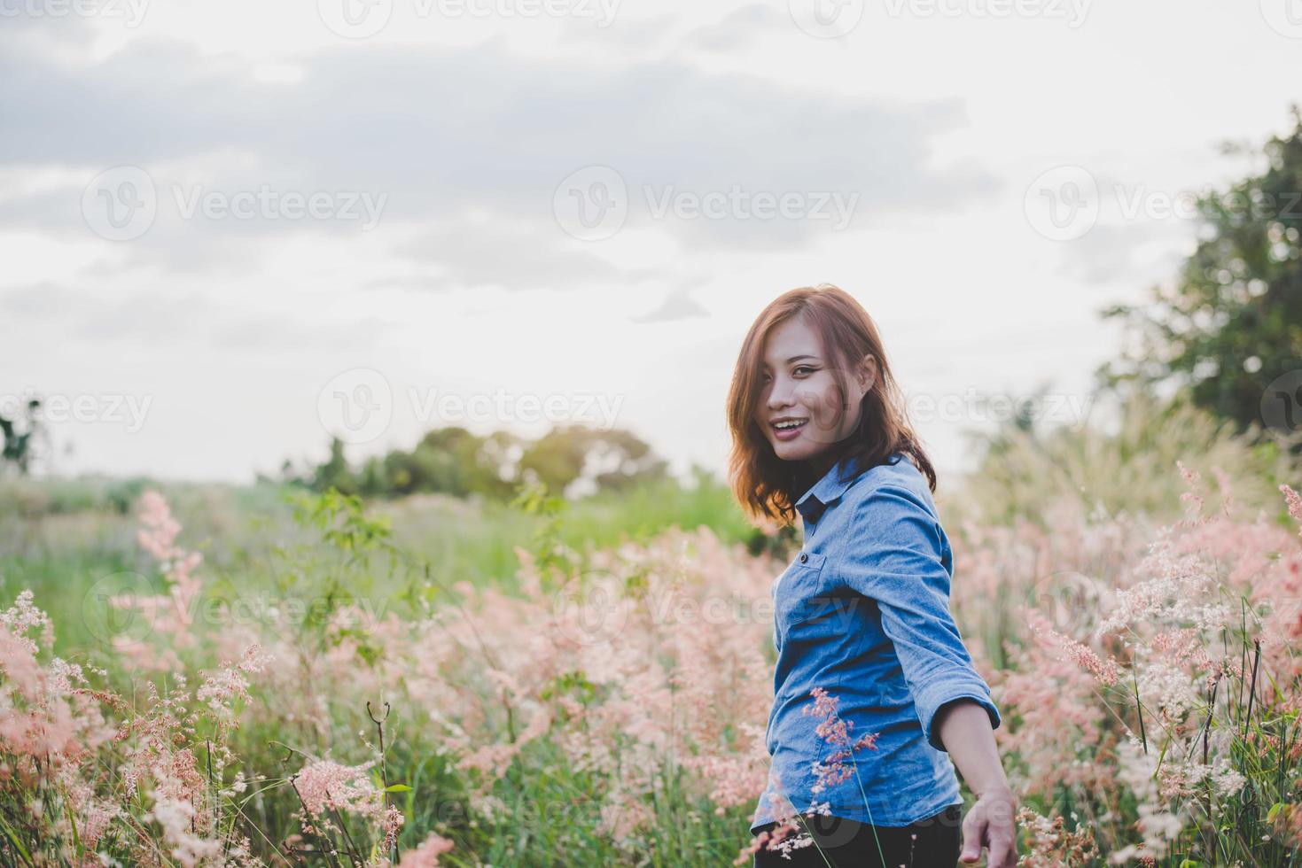 hipster jonge vrouw die reiziger het veld in leidt foto