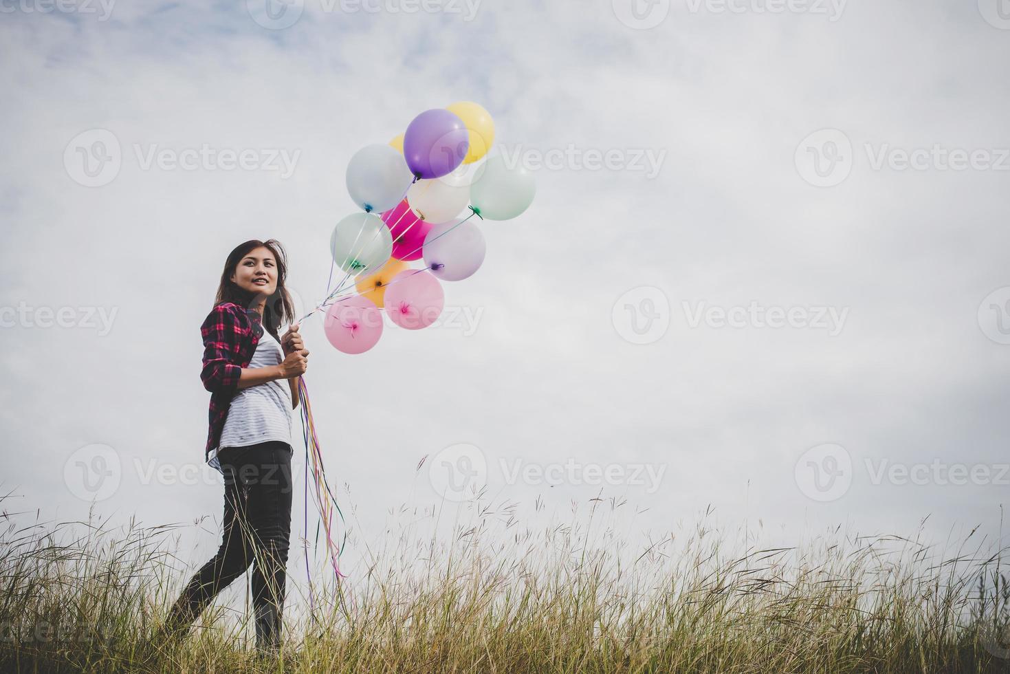 mooie jonge hipster vrouw met kleurrijke ballonnen buitenshuis foto