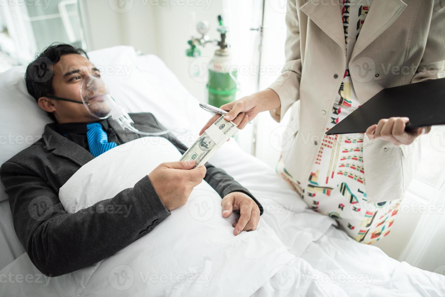 zakenman met zuurstofmasker werken vanuit bed geld overhandigen aan iemand foto