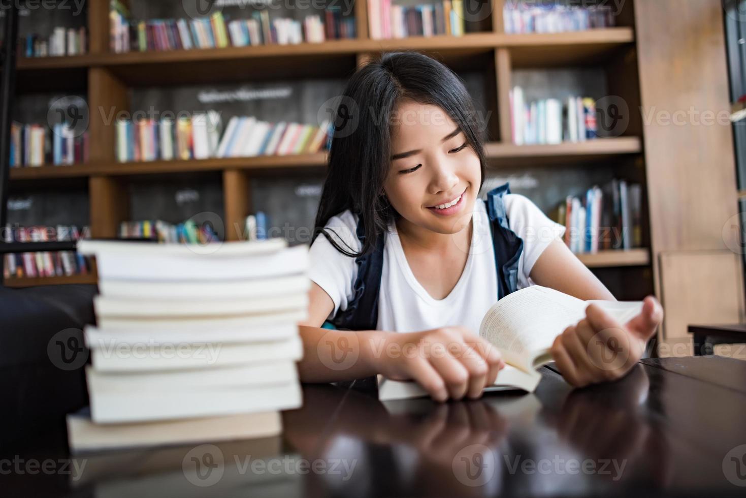 jonge vrouw leesboek binnen zitten in een stedelijk café foto