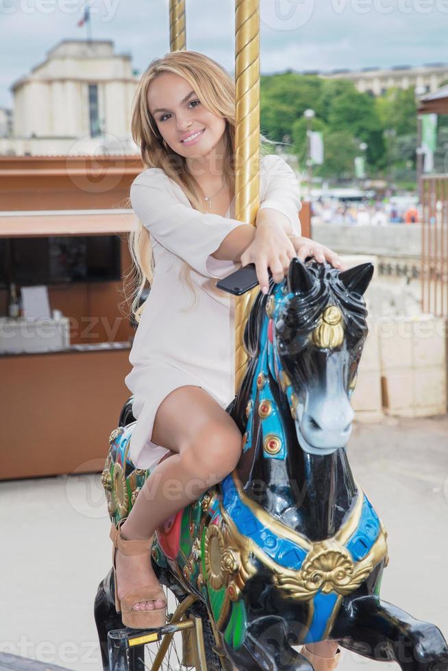 charmant vrouw poseren zittend Aan een carrousel foto