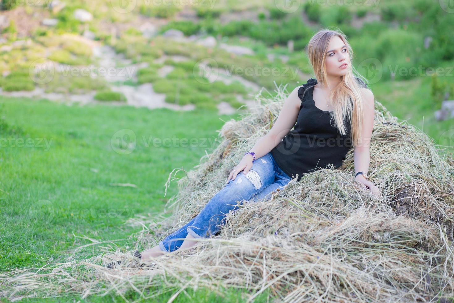 mooi dame poseren zittend Aan de hooi foto