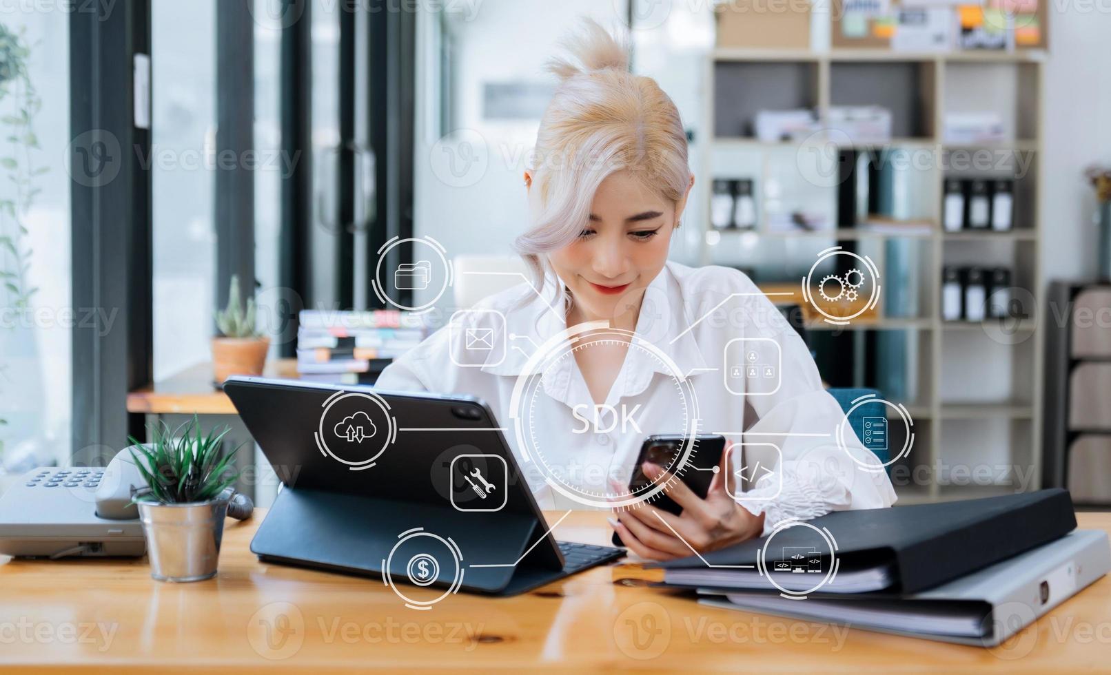 sdk software ontwikkeling uitrusting programmering taal technologie concept, persoon typen laptop computer en tablet met sdk icoon Aan virtueel scherm. in kantoor foto