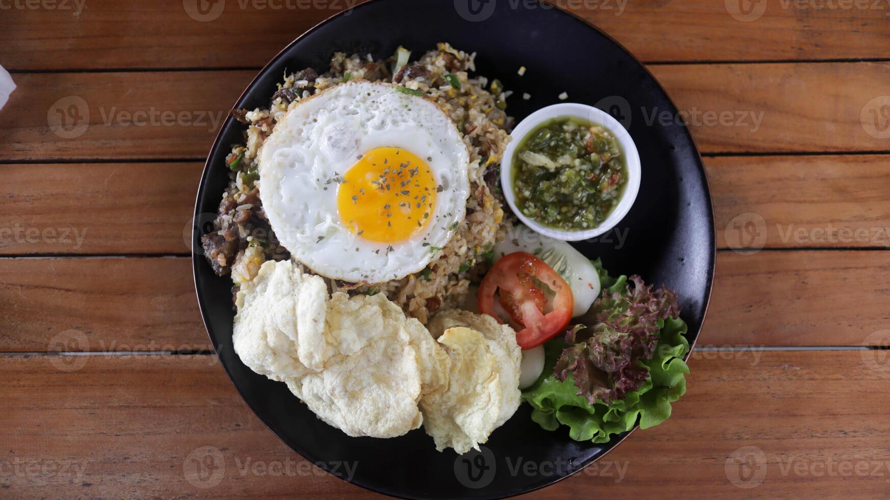 dorp gebakken rijst- of nasi goreng kampung gemaakt met veel van toppings, tomaat, gebakken ei, knapperig, en speciaal geolied puree Chili sommige vers groente. foto