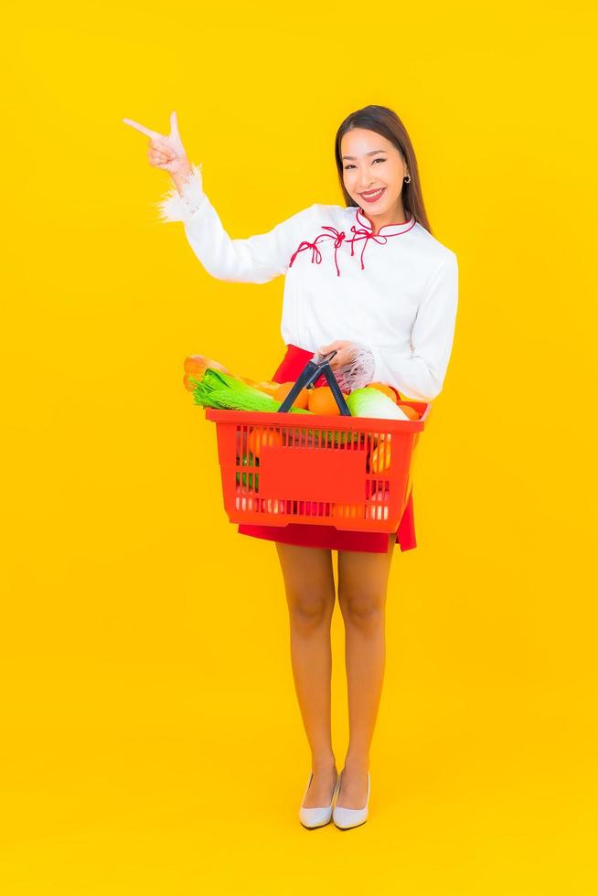 mooie jonge Aziatische vrouw met winkelmandje foto