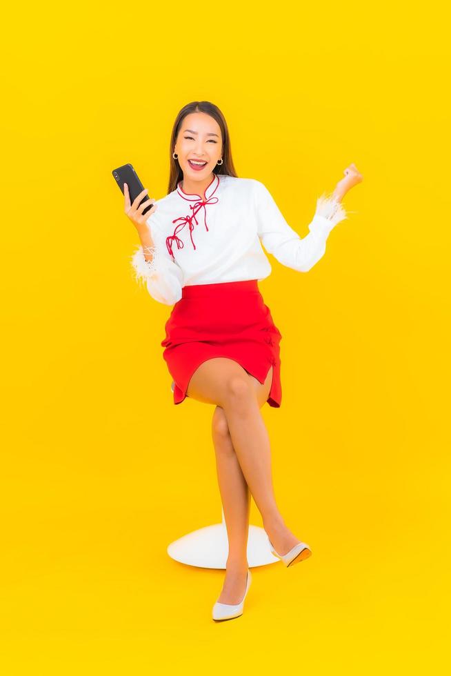 jonge Aziatische vrouw met slimme mobiele telefoon foto