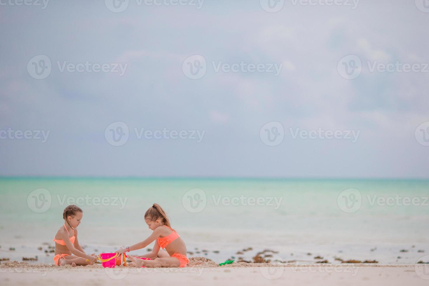 weinig meisjes spelen Aan de strand foto