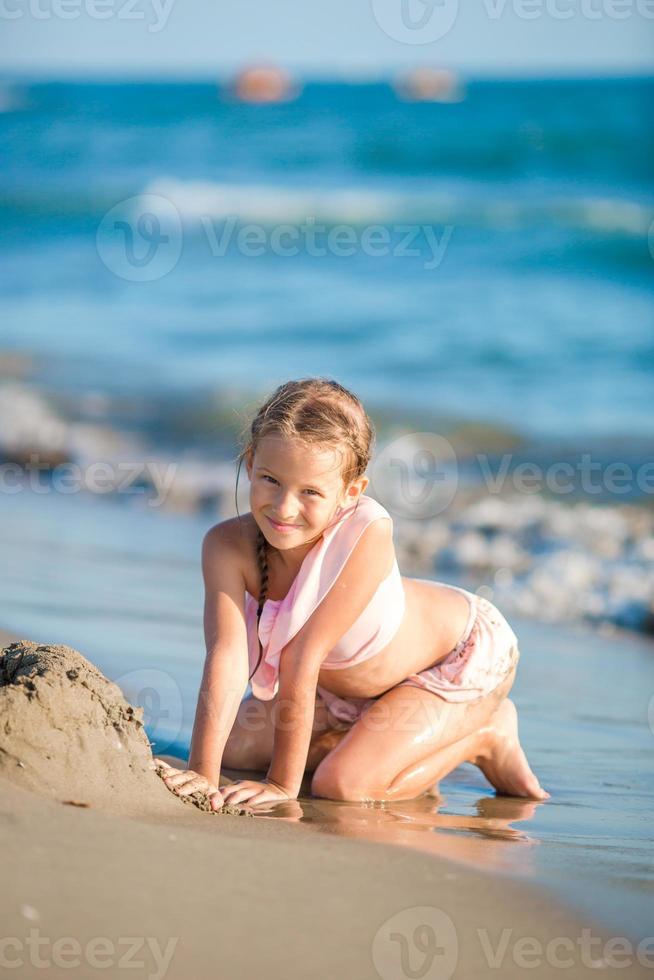 weinig meisje hebben pret Aan de strand foto