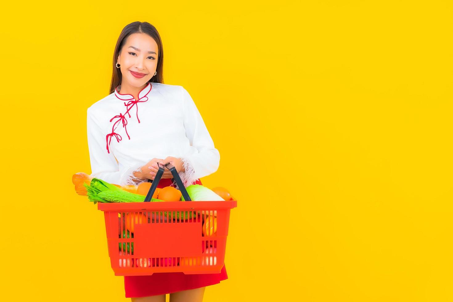 mooie jonge Aziatische vrouw met winkelmandje foto