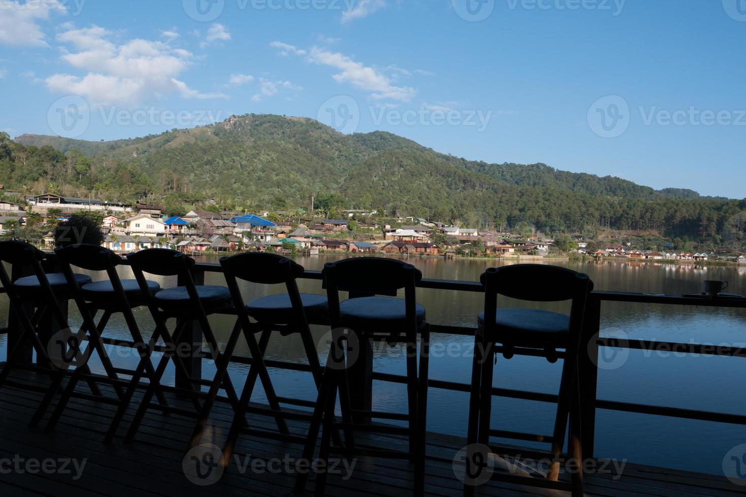 stoelen met uitzicht op een dorp en water foto