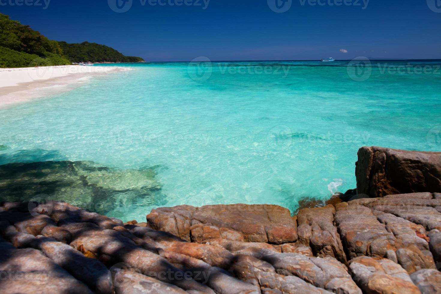 helder water en rotsen op een strand foto