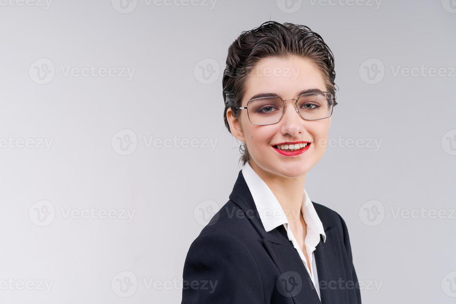 elegant jong bedrijf vrouw in zwart pak looks vol vertrouwen in camera. foto