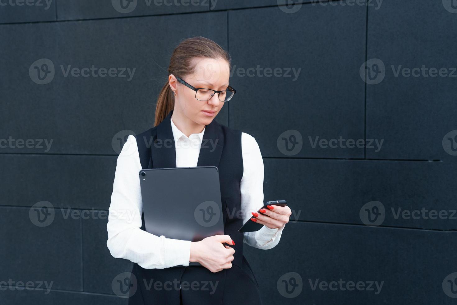 Kaukasisch bedrijf dame in pak Holding laptop en pratend Aan telefoon, poseren foto