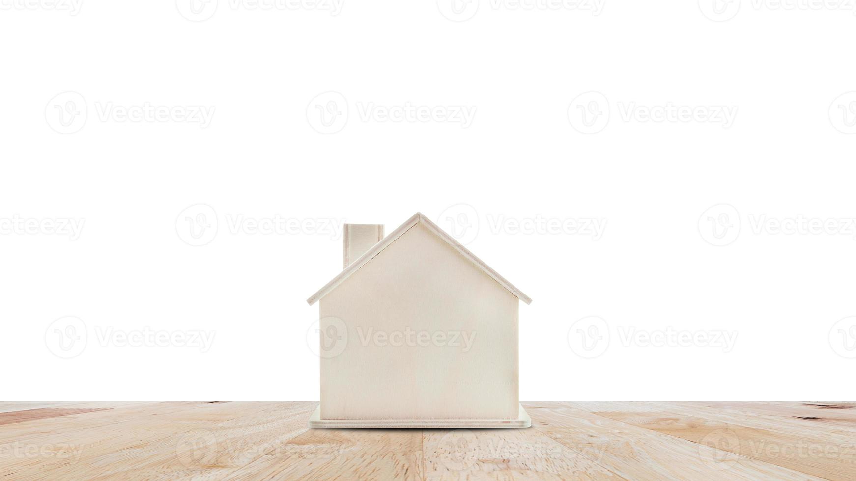 klein huis model- Aan houten tafel geïsoleerd Aan wit achtergrond.familie leven en bedrijf echt landgoed concept. foto