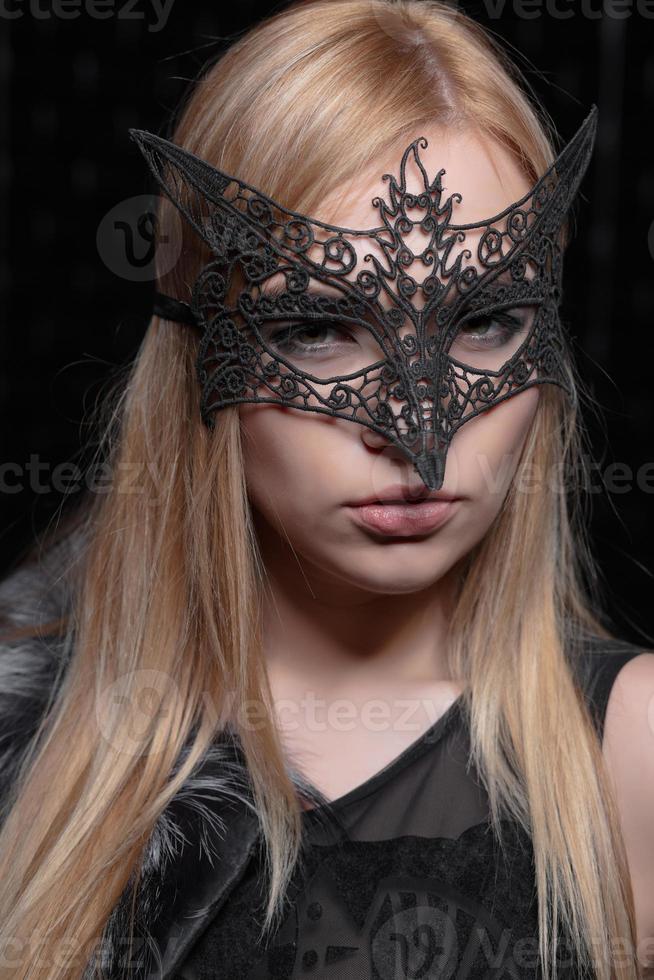 portret van een jong mooi blond in een masker foto