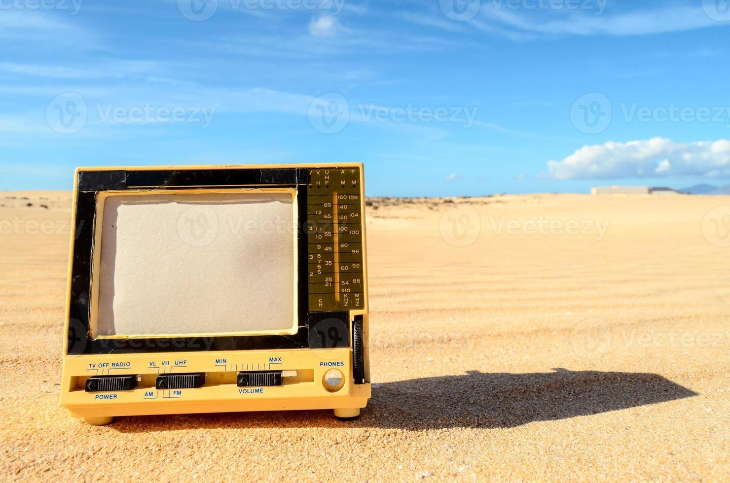 oud televisie in de zand foto