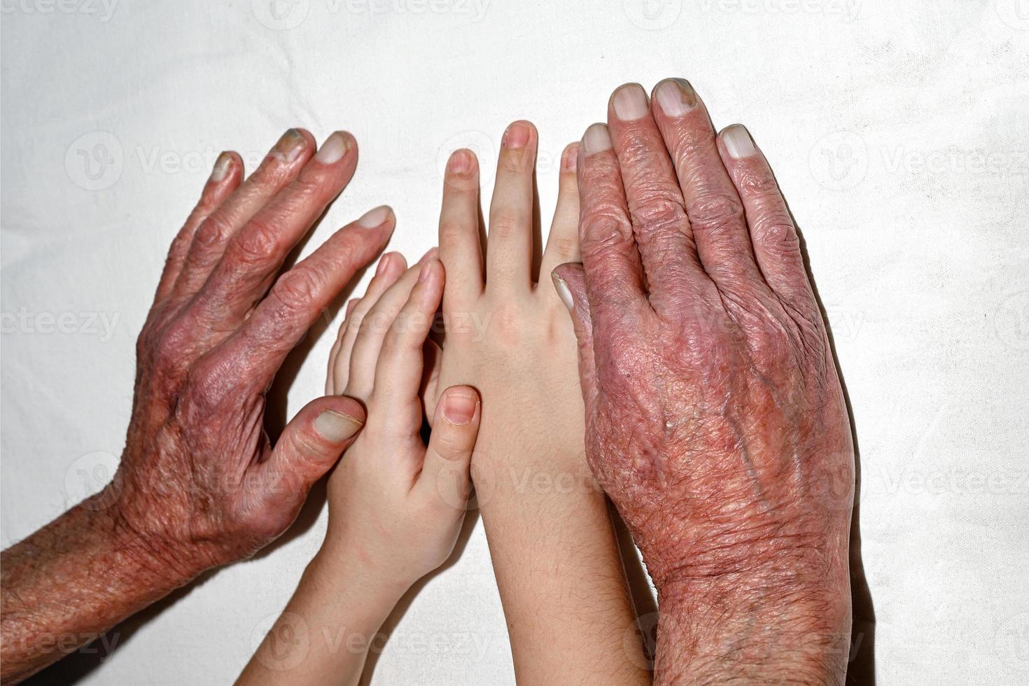 de handen van kinderen en de ouderen. een jong meisje Holding haar opa's hand- in de ziekenhuis. foto