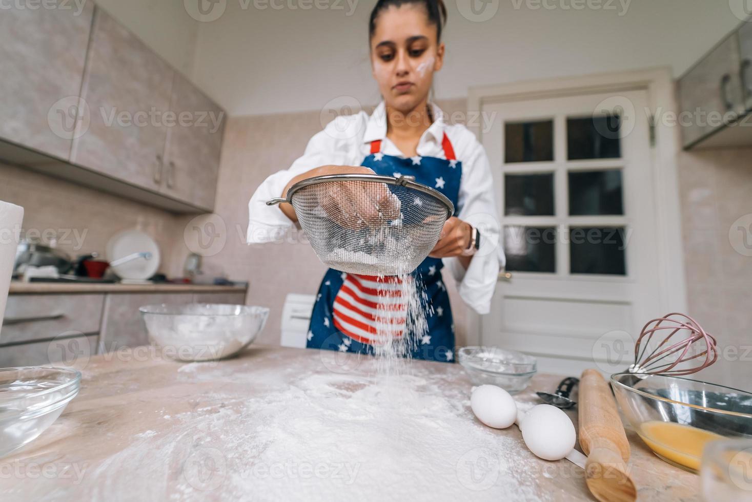 vrouw zeven meel door zeef. selectief focus. foto