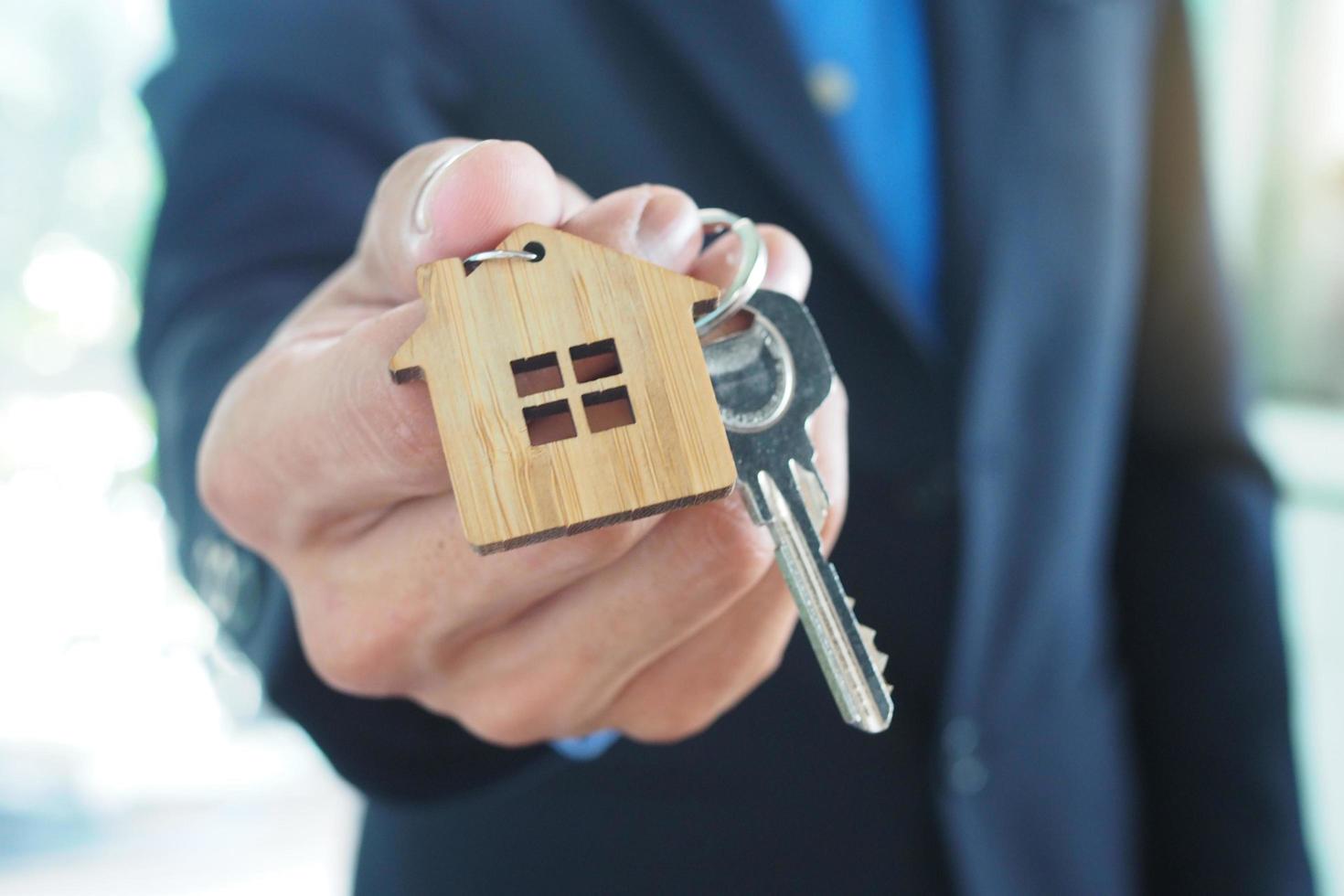 huis verkoop agenten zijn geven huis sleutels. huur een huis, kopen en verkopen concept foto