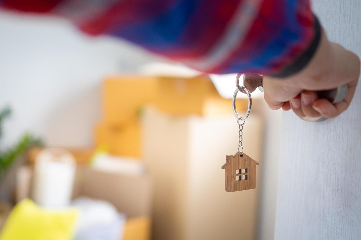 de nieuw huis eigenaar opent de deur van de kamer. binnen de kamer Daar zijn persoonlijk bezittingen dat zijn gaan naar worden verhuisd naar houden correct. huis in beweging concept. foto