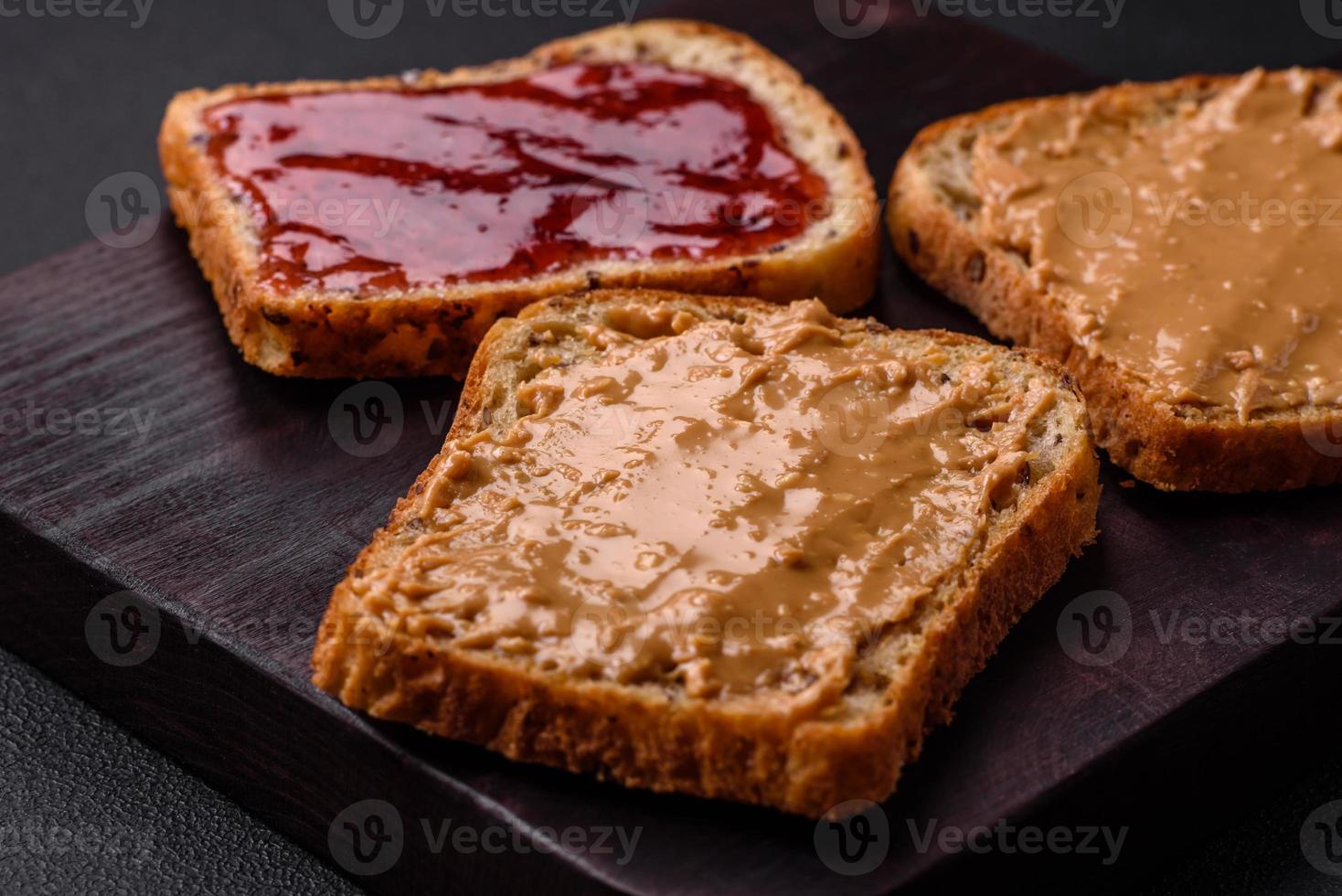 voedzaam boterhammen bestaande van brood, framboos jam en pinda boter foto