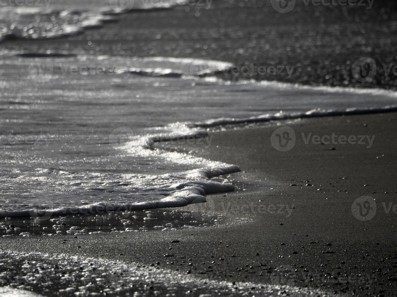 zee Golf schuim Aan de zand strand kust foto