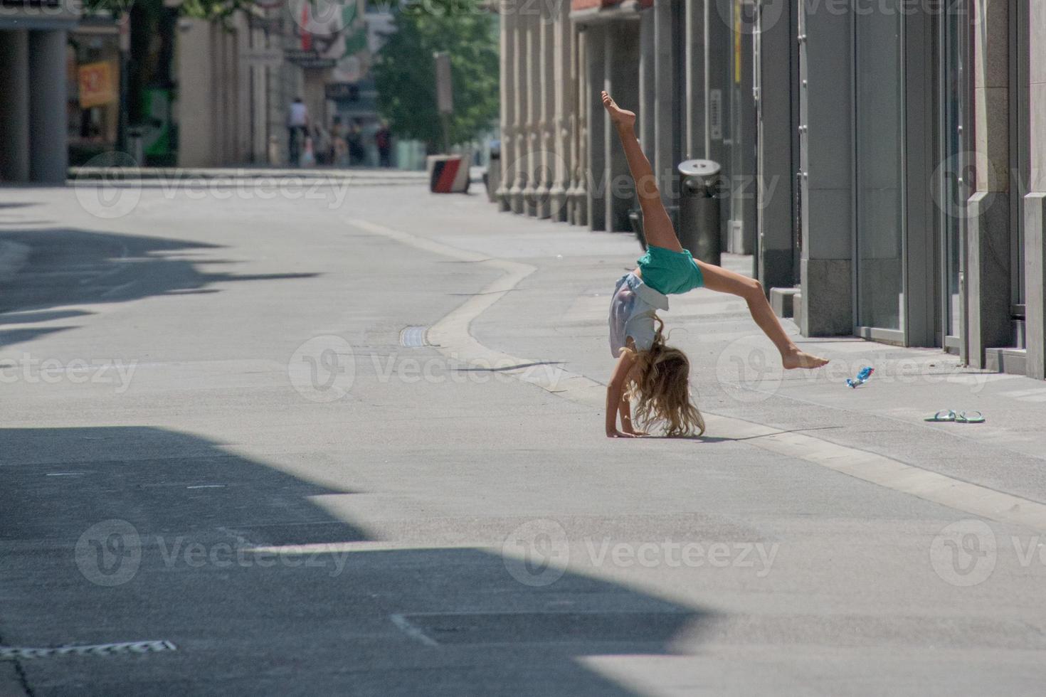 kind meisje maken salto in de straat foto