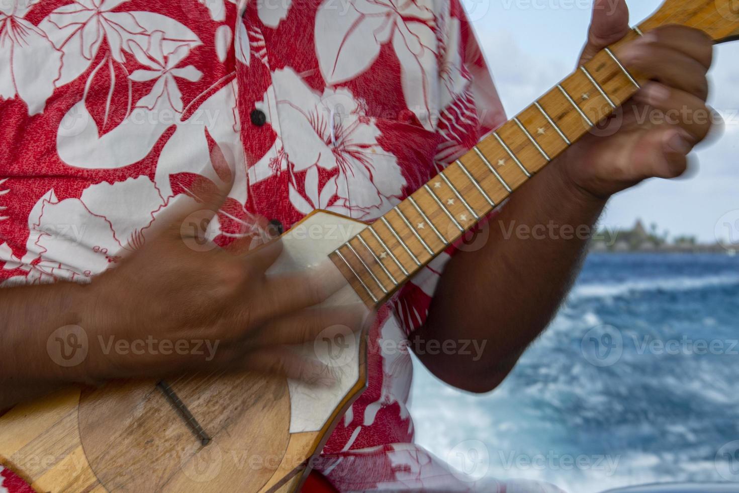 oud Mens handen spelen hukulele in Frans Polynesië foto