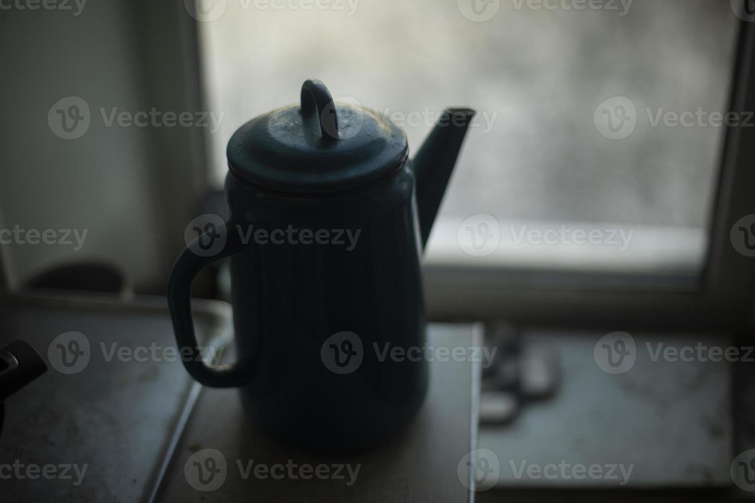 waterkoker Aan achtergrond van venster. waterkoker met handvat. silhouet van keuken gebruiksvoorwerpen. foto