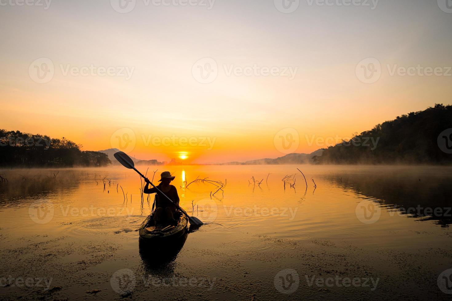 Dames Aan kajak rijen in de reservoir gedurende de zonsopkomst, harak Woud park huai naam Mens reservoir loei Thailand 21 jan 2023 foto