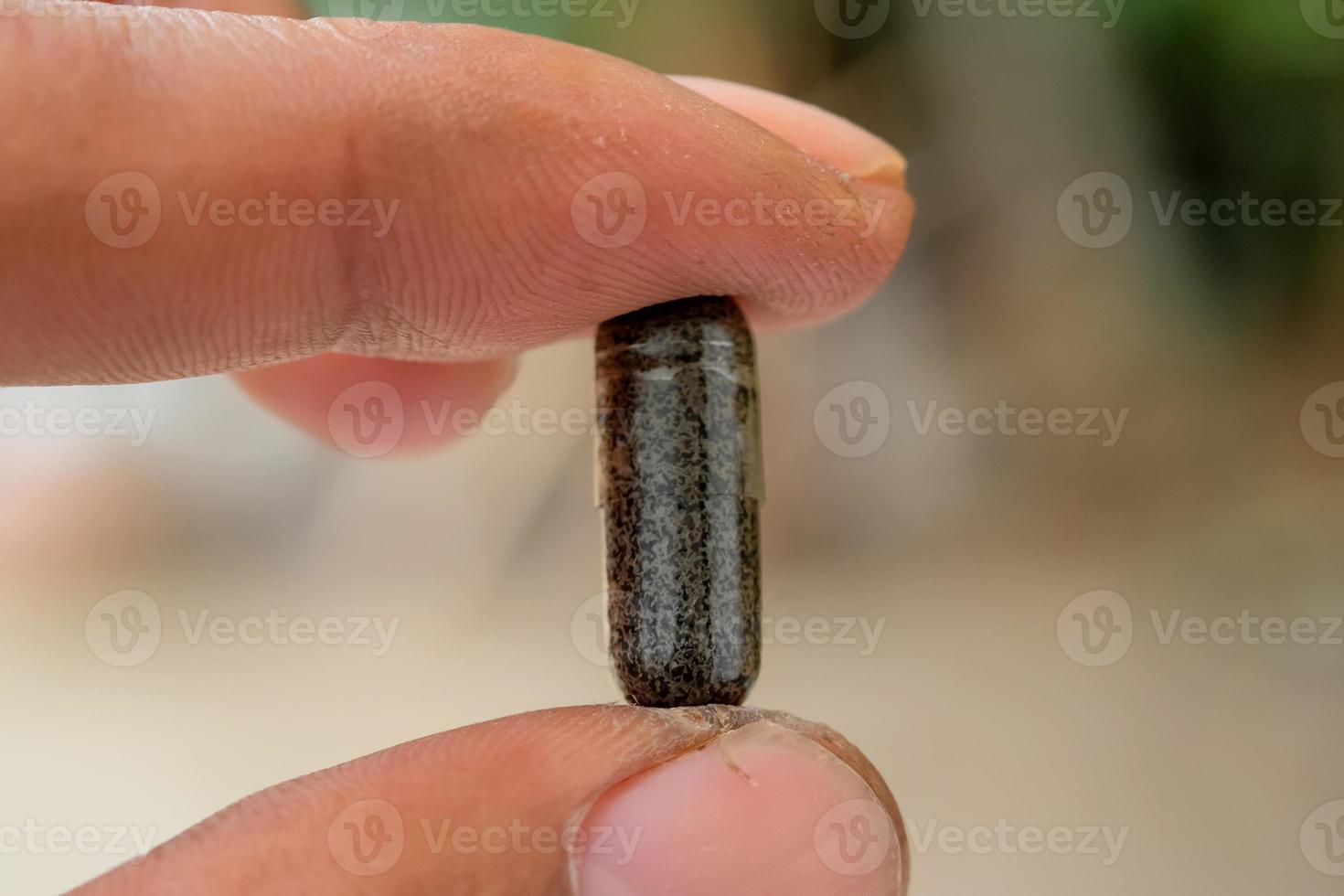 kruiden capsules van zwart komijn in menselijk hand. macro schot foto