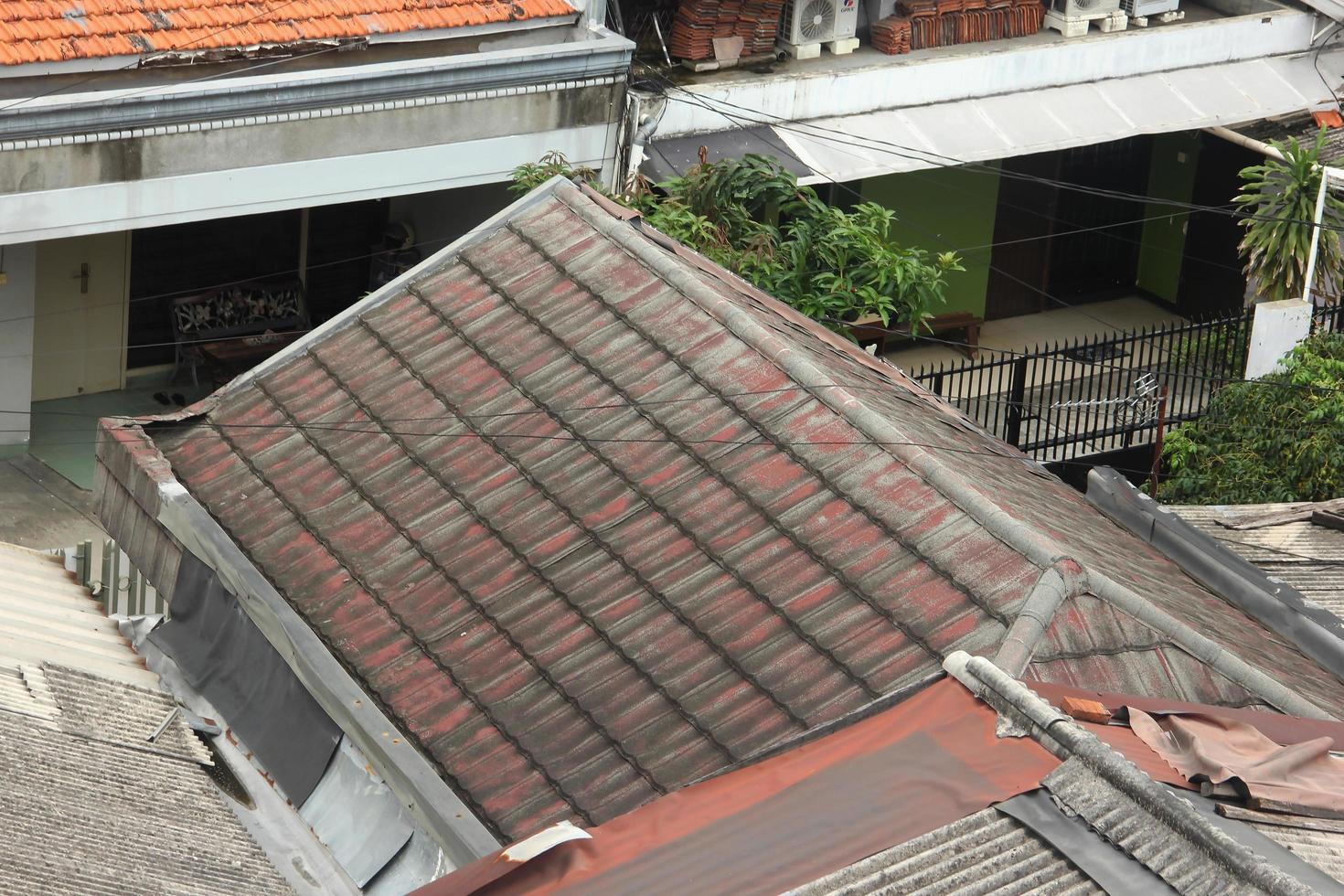 west Jakarta, Indonesië - februari 18e, 2023 - oud rood en stoffig huis dak foto geïsoleerd met woonachtig huizen achtergrond.